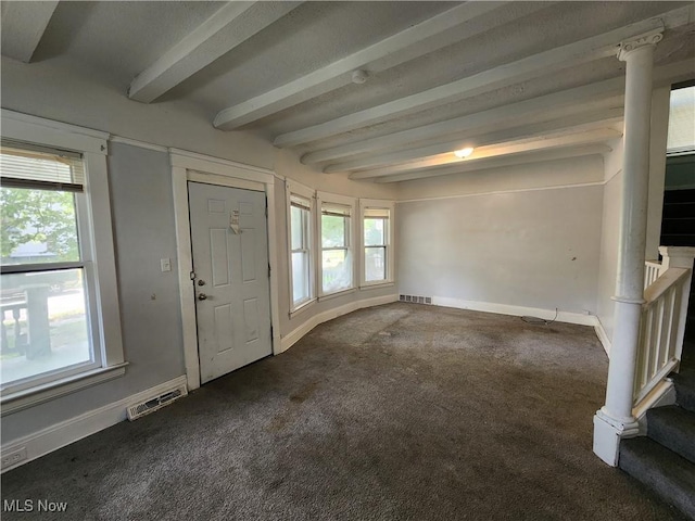 foyer entrance featuring beamed ceiling and dark carpet