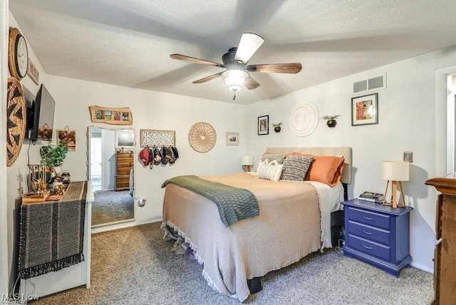 carpeted bedroom featuring a textured ceiling and ceiling fan