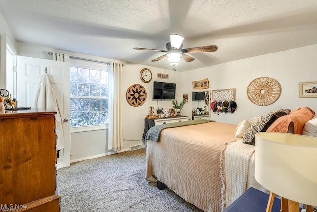 bedroom featuring a textured ceiling, carpet floors, and ceiling fan