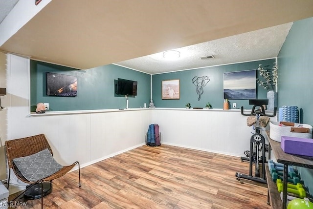 workout area featuring wood-type flooring and a textured ceiling