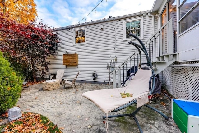 back of property with an outdoor fire pit and a patio area