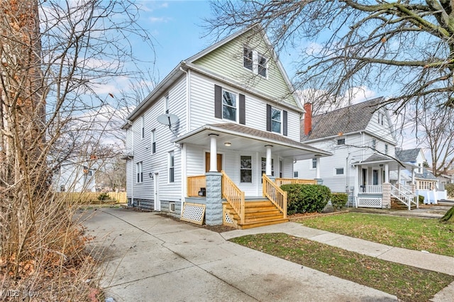 american foursquare style home featuring covered porch