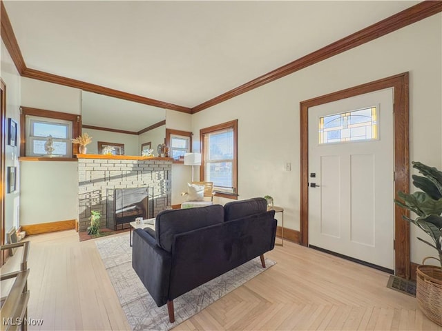 living room featuring light parquet floors, ornamental molding, and a brick fireplace