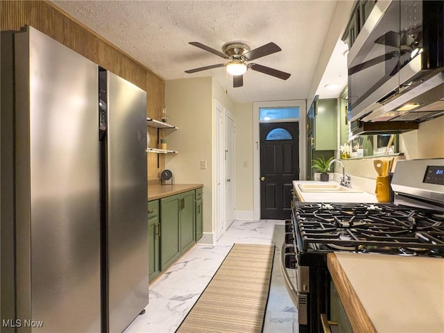 kitchen with appliances with stainless steel finishes, a textured ceiling, ceiling fan, sink, and green cabinets