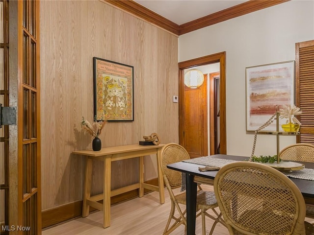 interior space with crown molding, wooden walls, and light hardwood / wood-style flooring