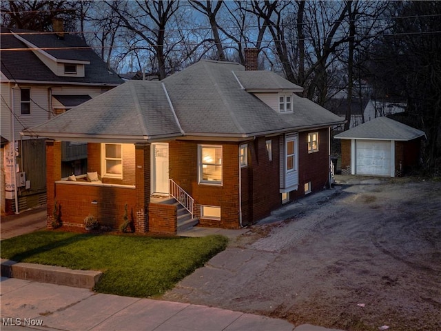 view of front of home featuring a garage, an outbuilding, and a front yard