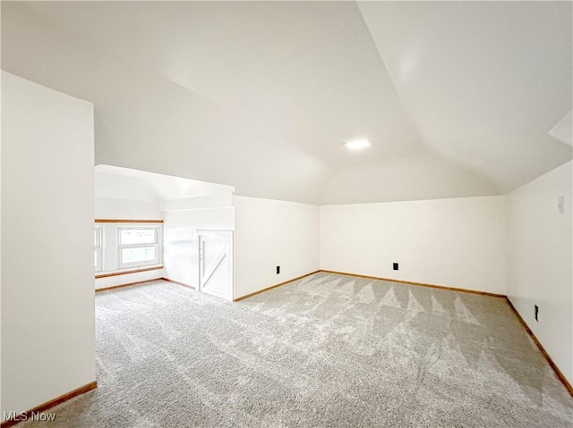 bonus room with carpet flooring and vaulted ceiling