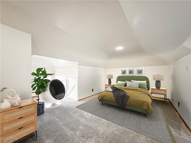 bedroom with dark colored carpet and vaulted ceiling