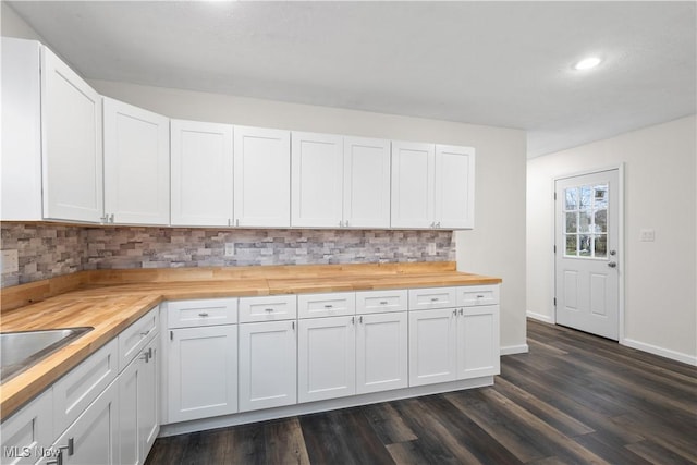 kitchen with wood counters, dark hardwood / wood-style flooring, backsplash, and white cabinets