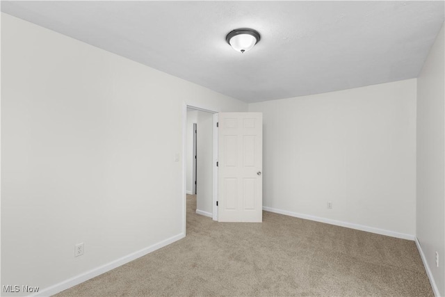 unfurnished room featuring light colored carpet