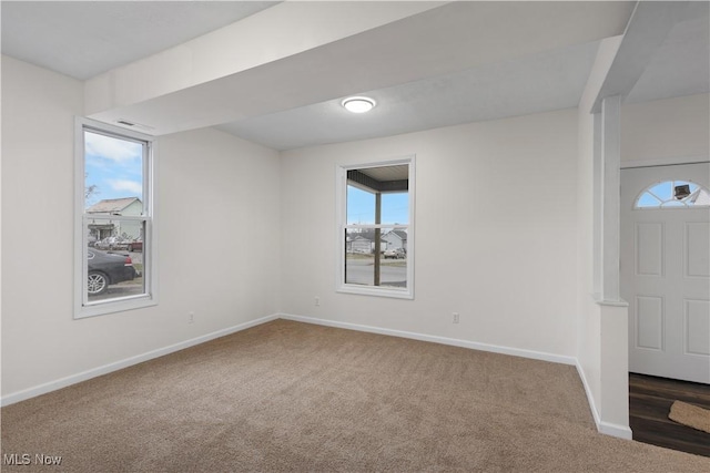 carpeted spare room featuring plenty of natural light