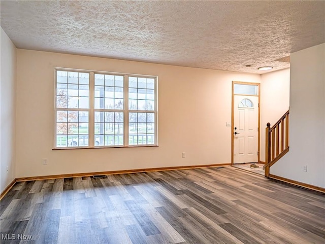 interior space featuring wood-type flooring and a textured ceiling