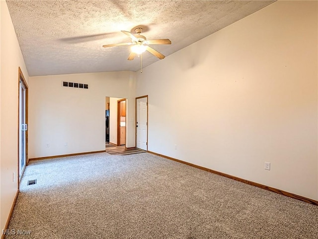 carpeted spare room with a textured ceiling, ceiling fan, and lofted ceiling