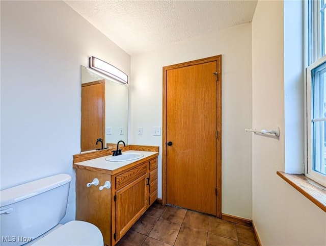 bathroom featuring vanity, toilet, and a textured ceiling