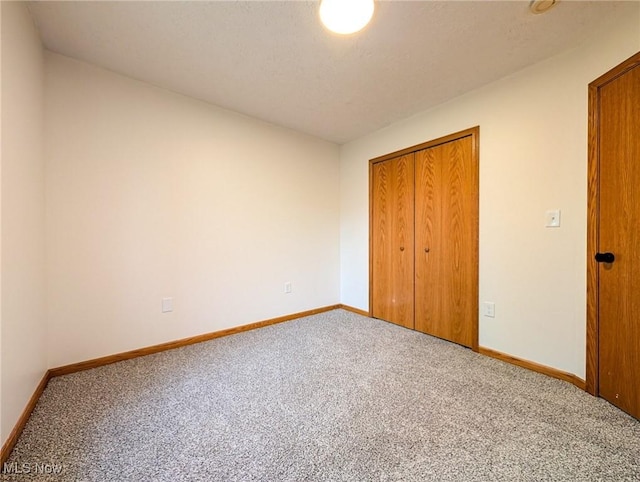 unfurnished bedroom with a closet and carpet floors