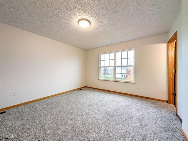 carpeted spare room featuring a textured ceiling