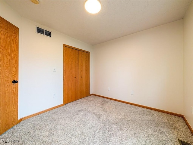 unfurnished bedroom featuring carpet flooring and a closet