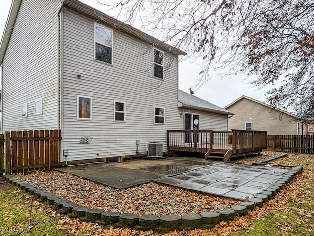 rear view of property with cooling unit, a patio, and a wooden deck