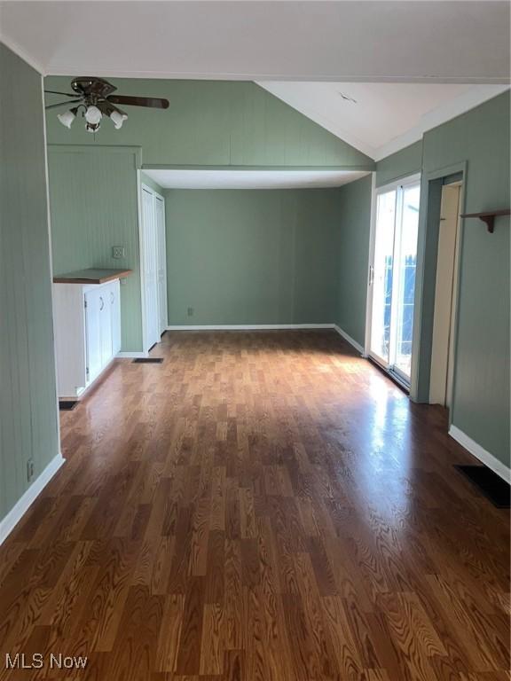 unfurnished living room featuring dark hardwood / wood-style flooring, ceiling fan, and lofted ceiling