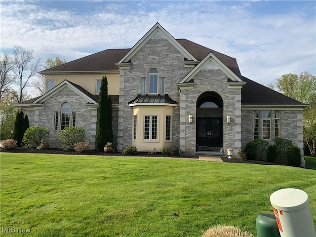 view of front of home with french doors and a front lawn