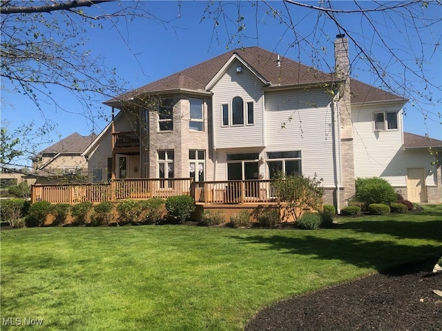 back of property with a wooden deck and a yard