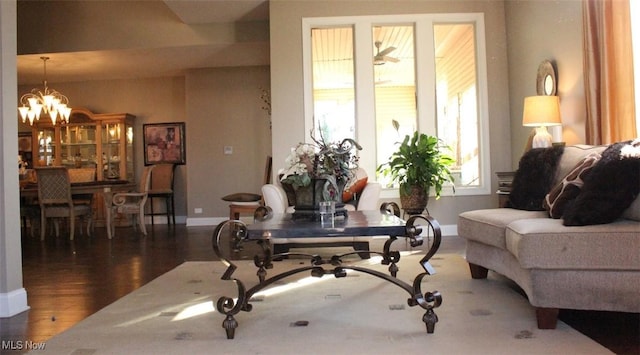 living area with dark wood-type flooring and a notable chandelier