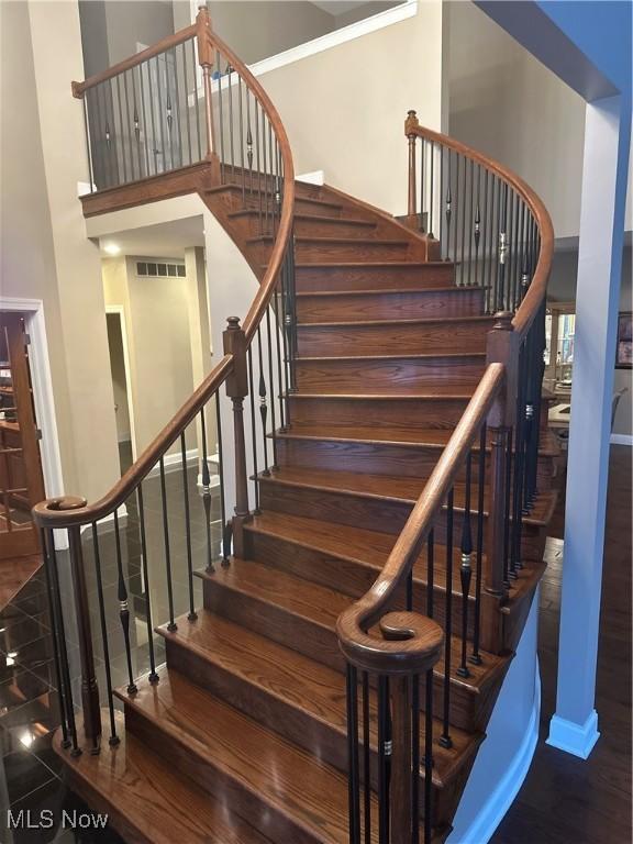 staircase featuring a towering ceiling