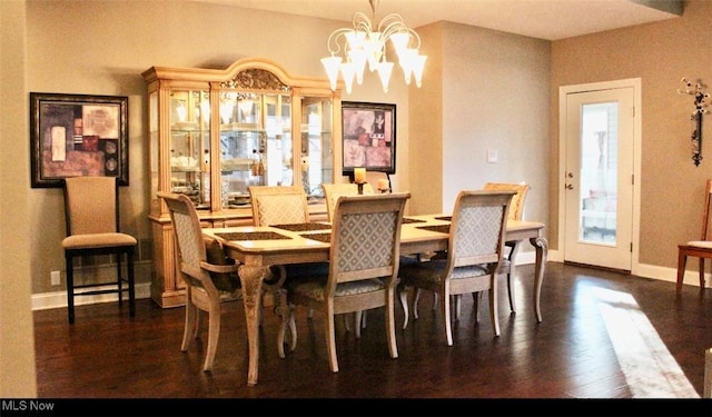 dining space with a chandelier and dark hardwood / wood-style flooring