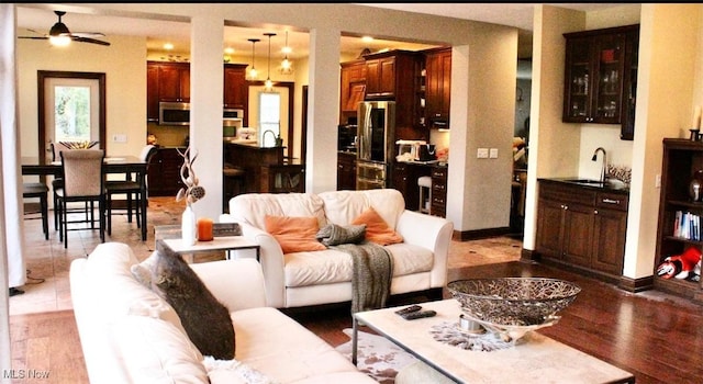 living room with ceiling fan, sink, and light hardwood / wood-style flooring