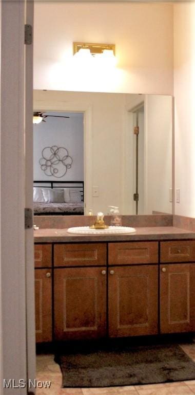 bathroom with tile patterned floors, vanity, and ceiling fan