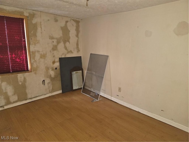 empty room featuring a textured ceiling and hardwood / wood-style flooring