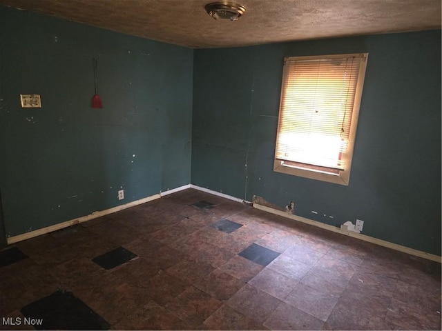 unfurnished room with a textured ceiling