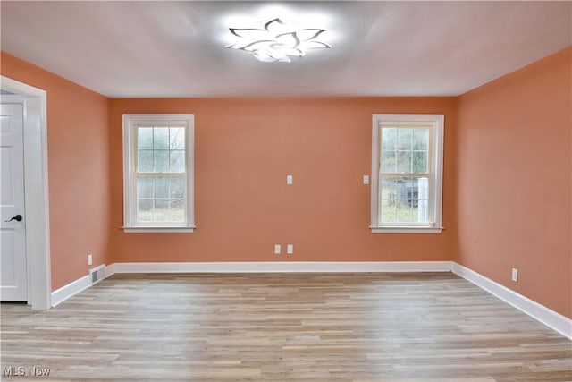 empty room featuring plenty of natural light and light hardwood / wood-style flooring