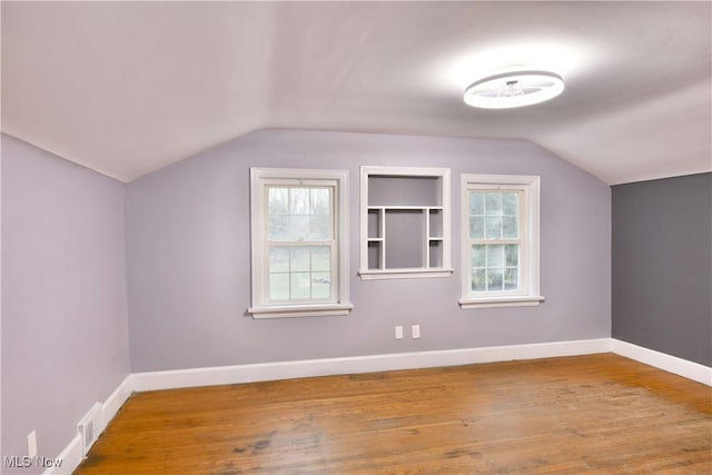 bonus room featuring hardwood / wood-style floors, lofted ceiling, and a healthy amount of sunlight