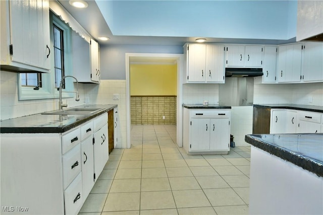 kitchen with light tile patterned floors, white cabinetry, and sink