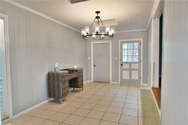 tiled entrance foyer with crown molding and an inviting chandelier