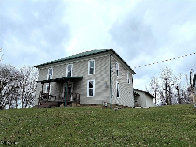 rear view of property featuring a lawn