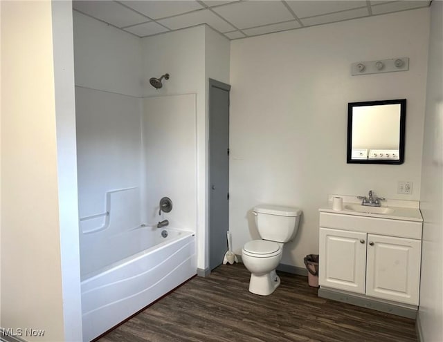 full bathroom featuring a paneled ceiling, vanity, bathing tub / shower combination, hardwood / wood-style flooring, and toilet