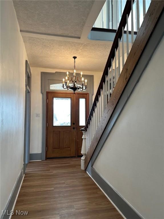 foyer entrance with dark wood-type flooring and a chandelier