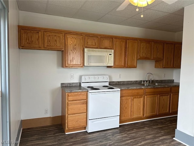 kitchen with white appliances, dark hardwood / wood-style floors, ceiling fan, and sink