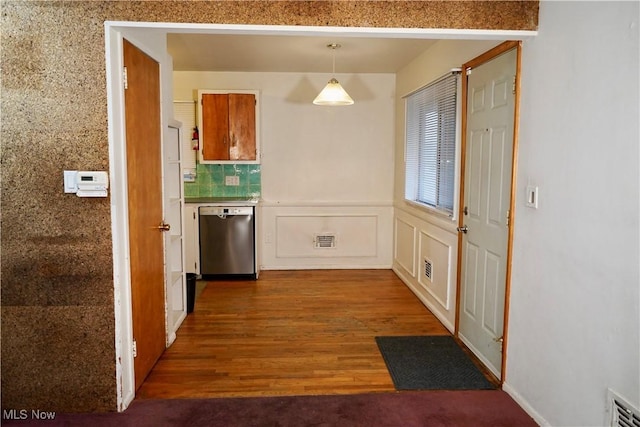 kitchen featuring dark hardwood / wood-style flooring, decorative backsplash, hanging light fixtures, and stainless steel dishwasher