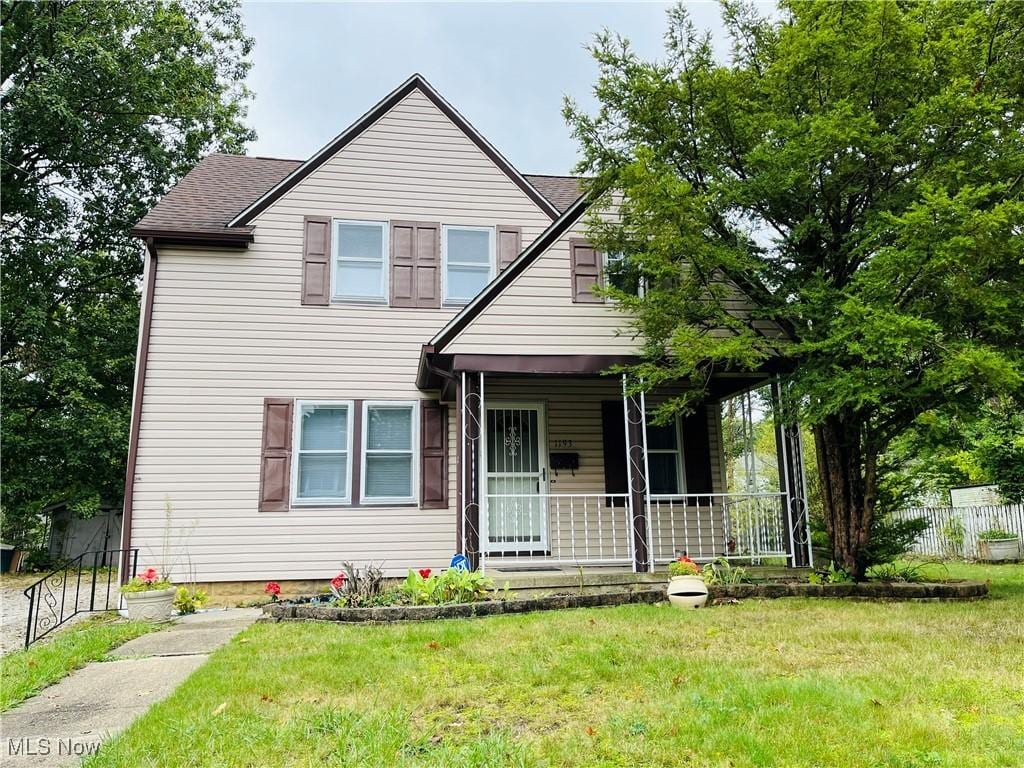 view of front of home with covered porch and a front lawn