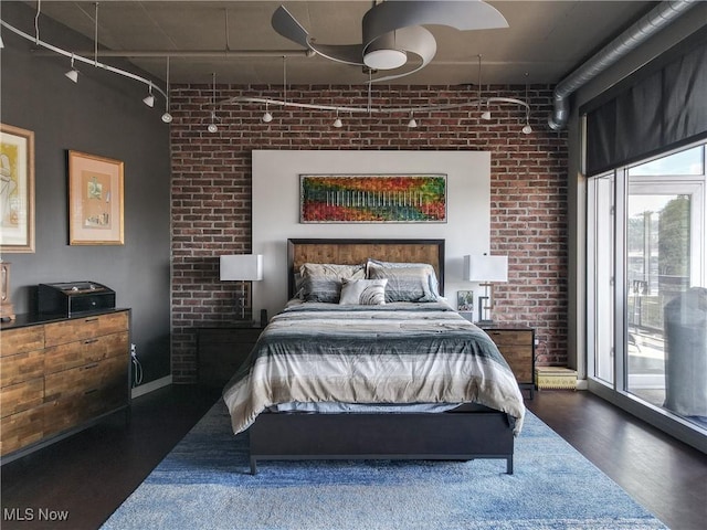 bedroom featuring ceiling fan, access to exterior, and brick wall