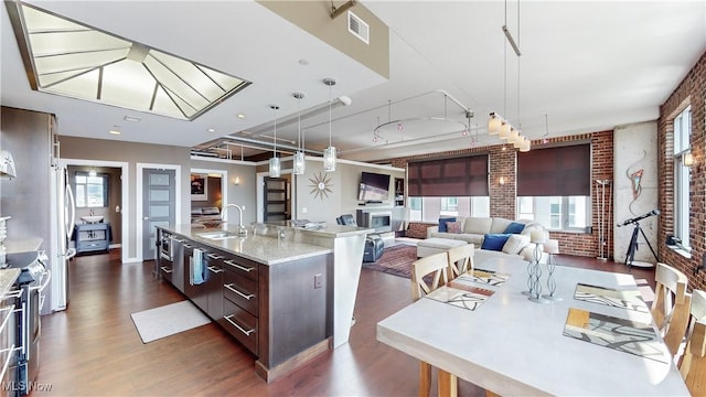 21 Furnace St Unit 705, Akron, OH 44308 - kitchen with brick wall, a sink, dark wood-style floors, a kitchen island with sink, and stainless steel electric range