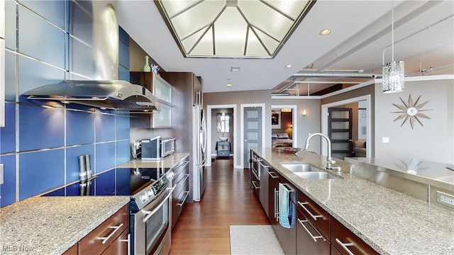 21 Furnace St Unit 705, Akron, OH 44308 - kitchen featuring appliances with stainless steel finishes, a sink, wall chimney range hood, dark wood finished floors, and light stone countertops