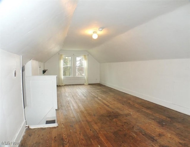 bonus room with wood-type flooring, vaulted ceiling, and washer / dryer