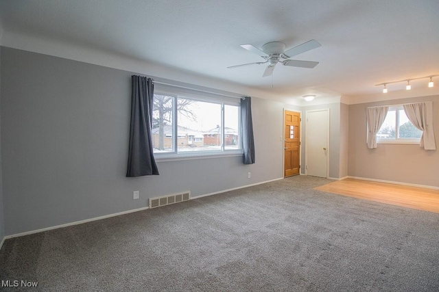 carpeted spare room featuring ceiling fan