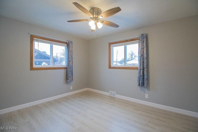 spare room featuring ceiling fan, light hardwood / wood-style flooring, and plenty of natural light