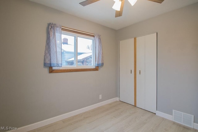 unfurnished bedroom featuring ceiling fan, light hardwood / wood-style floors, and a closet