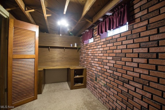 basement with carpet flooring and brick wall